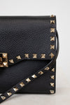 Black studded handbag on a light gray background