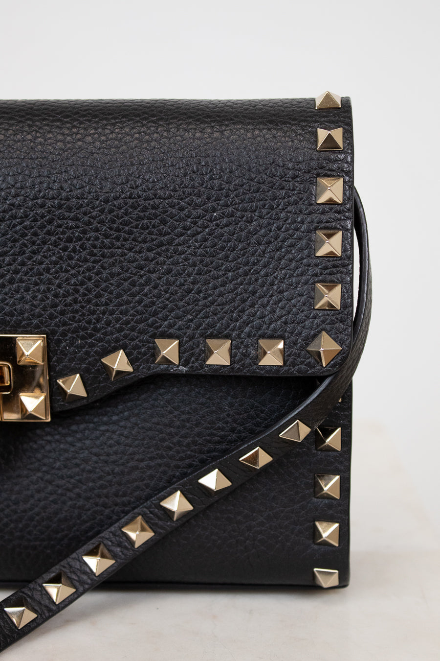 Black studded handbag on a light gray background