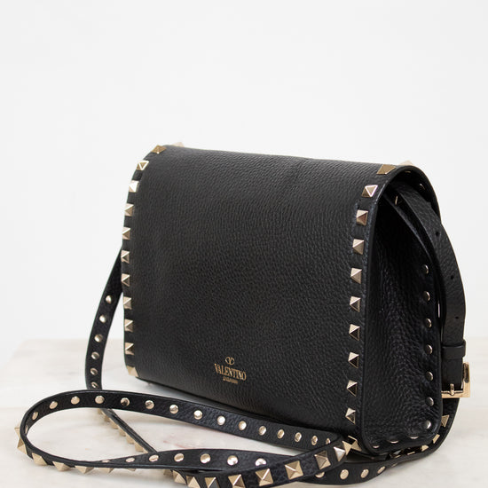 Black handbag with gold studs on a white background