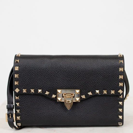 Black handbag with gold accents on a white background