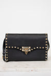 Black handbag with gold accents on a white background