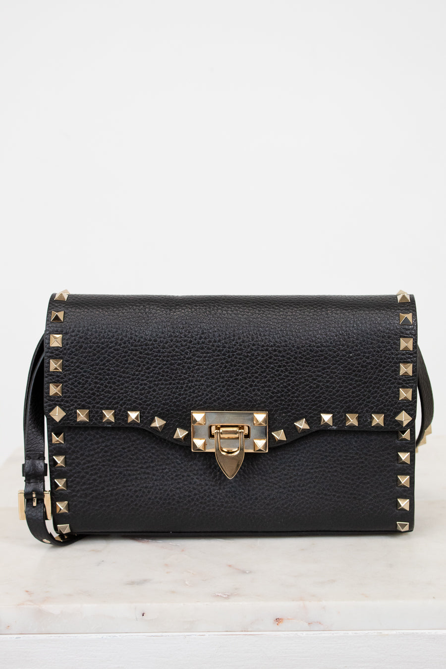 Black handbag with gold accents on a white background