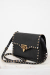Black handbag with gold studs and a clasp on a white background