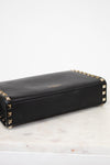 Black wallet with gold accents on a light marble surface