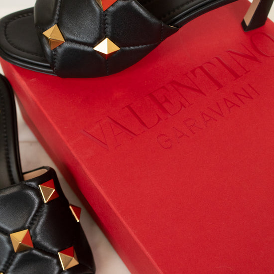 Black sandals with gold studs on a red Valentino box