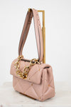 Pink handbag with gold chain detail on a white background
