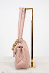 Pink handbag with gold chain detail on a white background