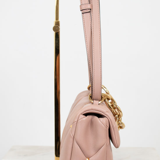 Pink handbag with gold chain on a white background