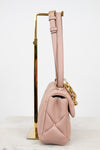 Pink handbag with gold chain on a white background