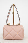 Pink quilted handbag with gold accents on a white background