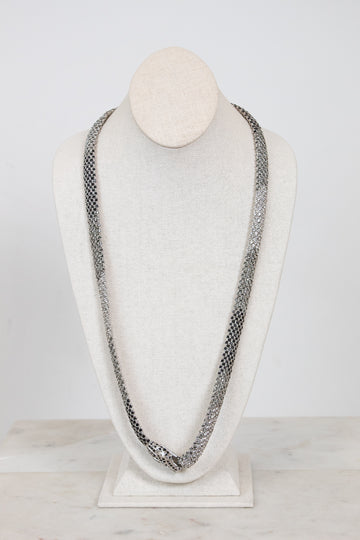 Long chain necklace on a mannequin bust against a white background