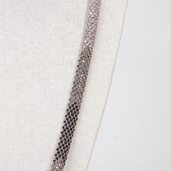 Close-up of a detailed necklace with rhinestone details on a textured fabric background