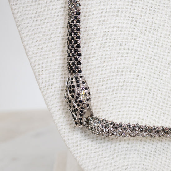 Close-up of a sparkling necklace on a white textured bust