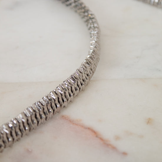 Silver necklace on a marble surface