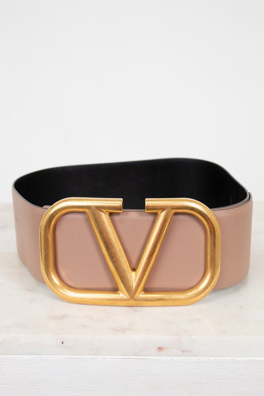 Belt with a gold 'V' buckle on a light background