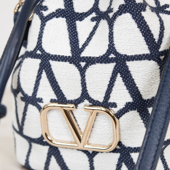 Navy and white patterned bag with gold logo on a light background