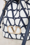 Navy and white patterned bag with gold logo on a light background