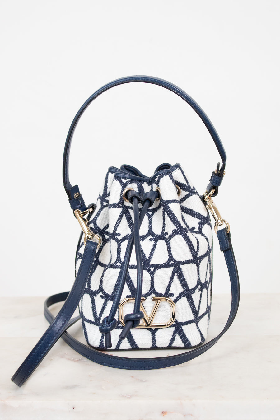 Designer handbag with blue and white pattern on a light background