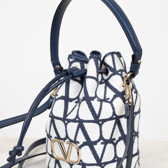 Designer handbag with geometric pattern and visible brand logo on a light background