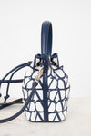 Navy and white patterned handbag on a light background
