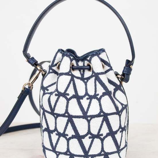 Navy and white patterned bucket bag on a light gray background