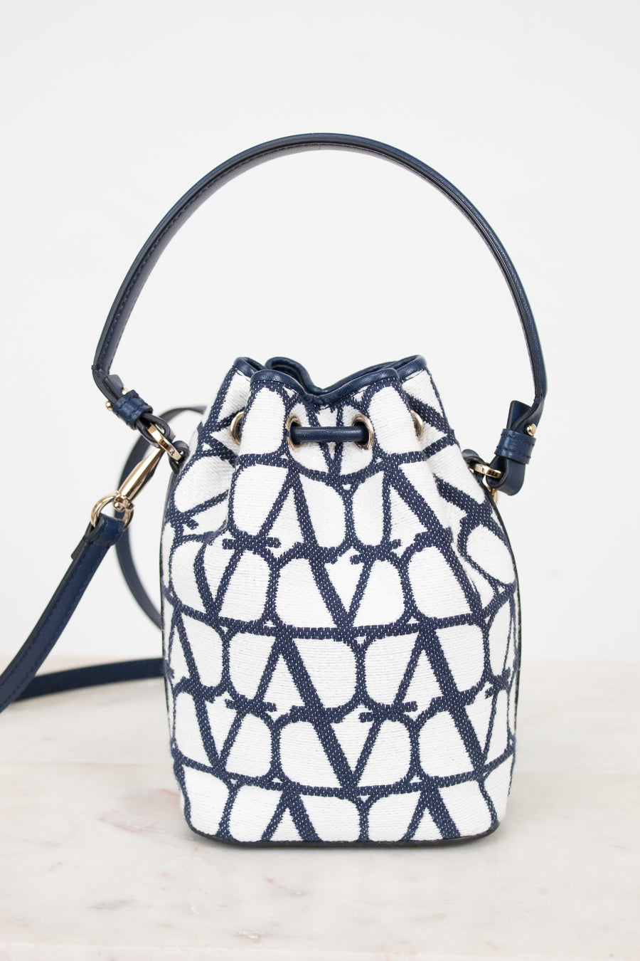 Navy and white patterned bucket bag on a light gray background