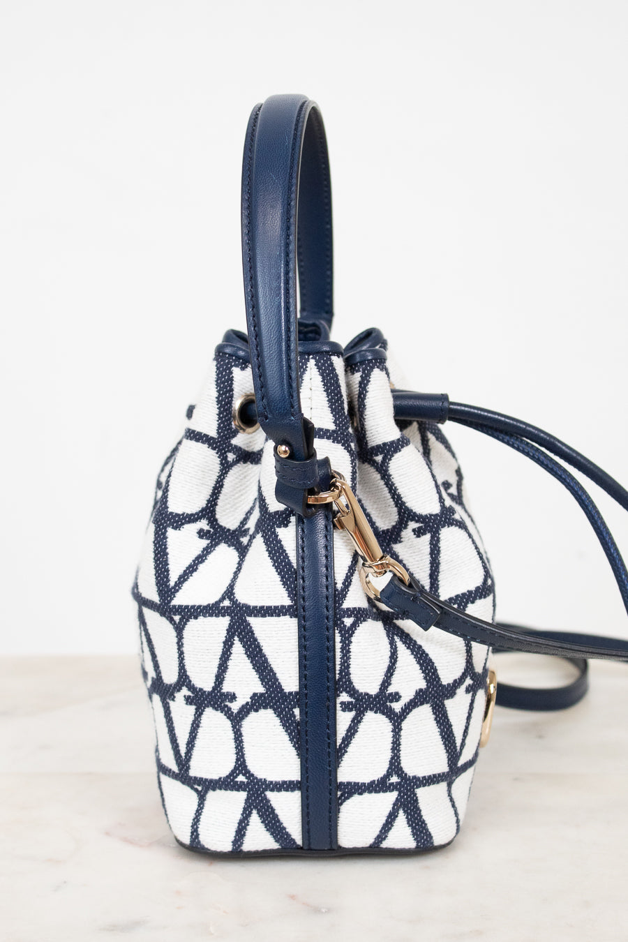 Navy and white patterned handbag on a light background