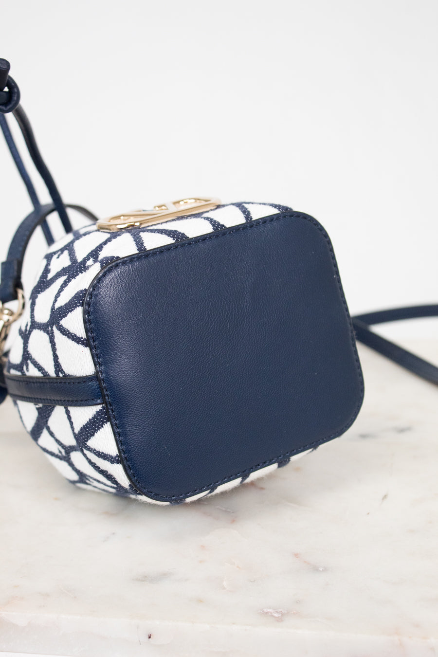 Navy blue and white patterned handbag on a light marble surface