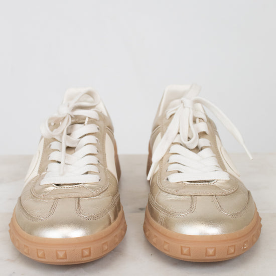 Front toe view of gold lace-up sneakers
