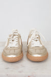 Front toe view of gold lace-up sneakers