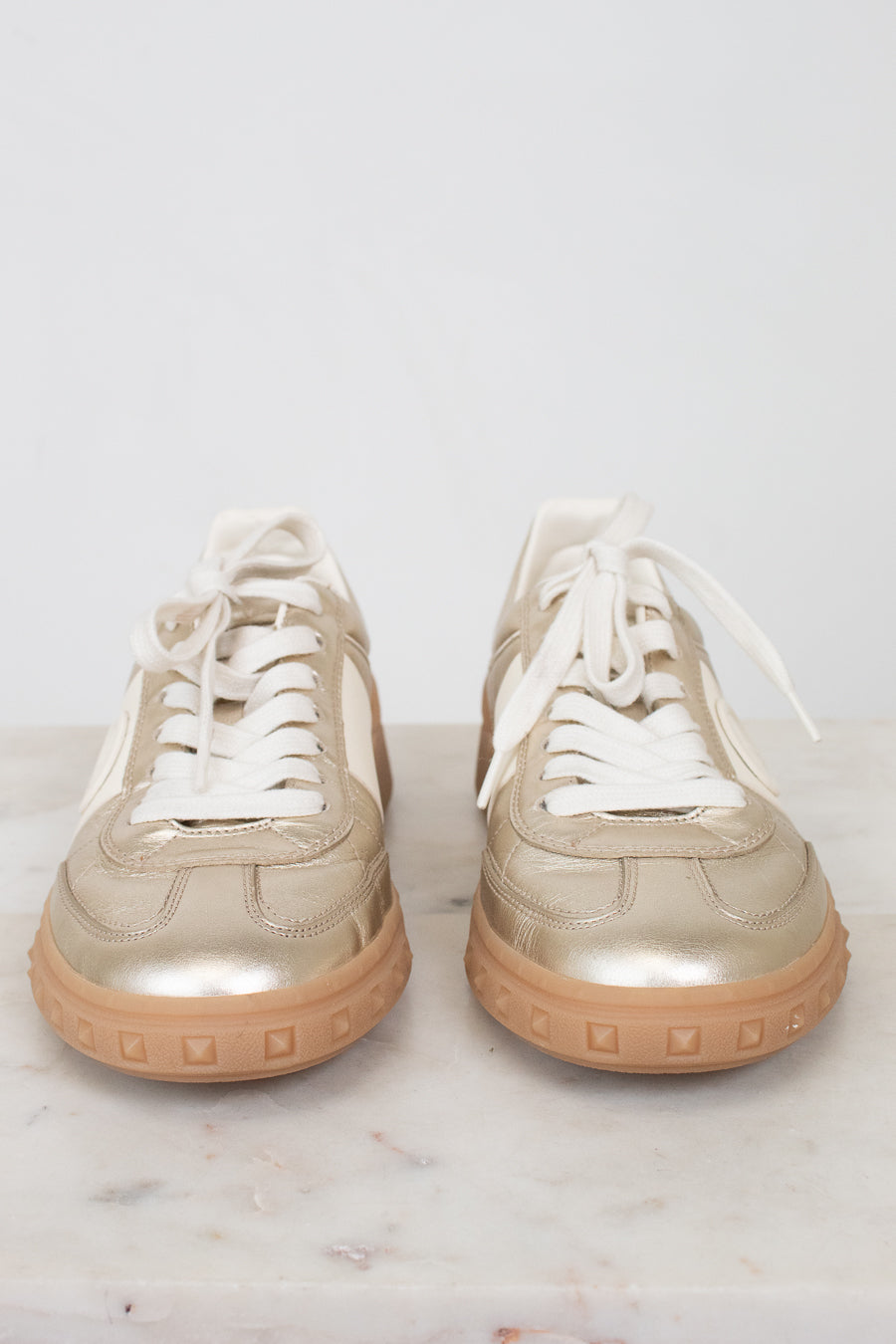 Front toe view of gold lace-up sneakers
