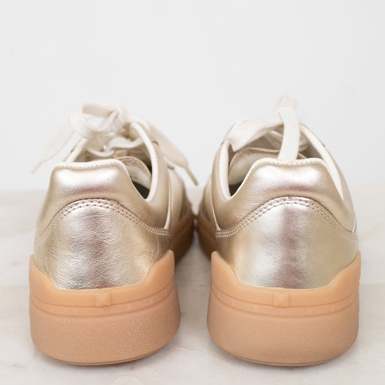 Heel view of gold sneakers with gum soles
