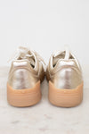 Heel view of gold sneakers with gum soles