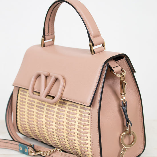 Pink handbag with woven pattern on a light background