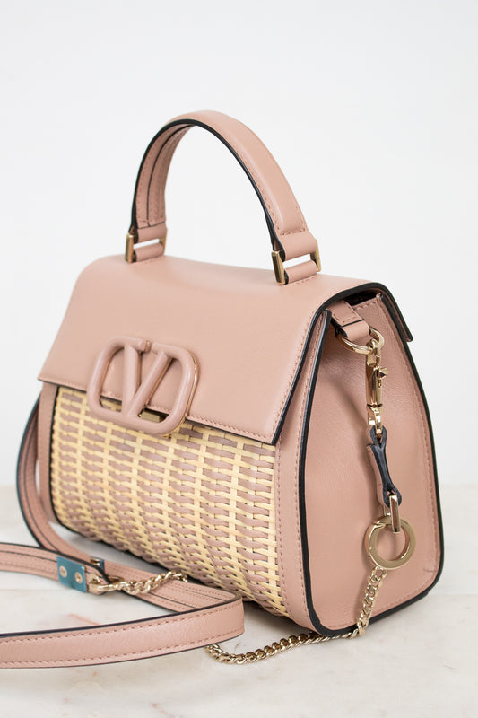 Pink handbag with woven pattern on a light background