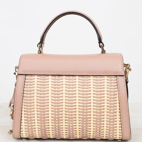 Pink handbag with wicker design on a white background