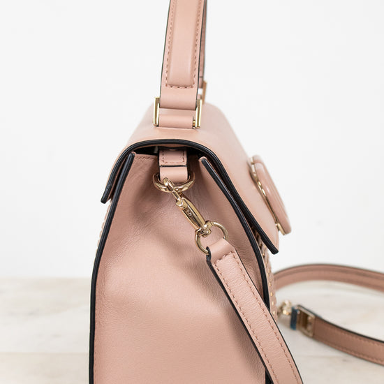 Pink handbag with a strap on a light background