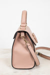 Pink handbag with a strap on a light background
