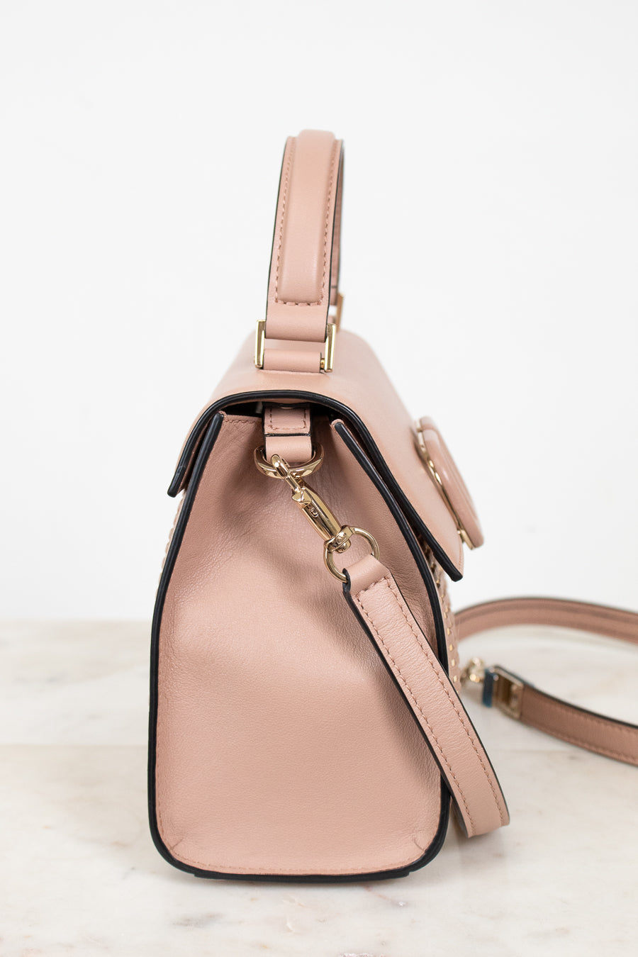 Pink handbag with a strap on a light background