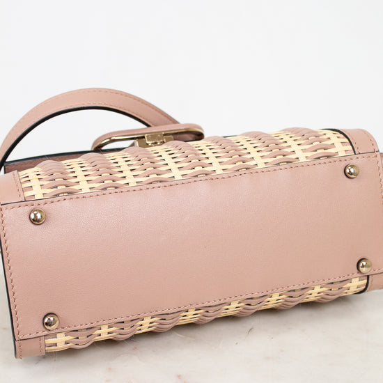 Pink handbag with woven pattern on a marble surface