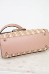 Pink handbag with woven pattern on a marble surface