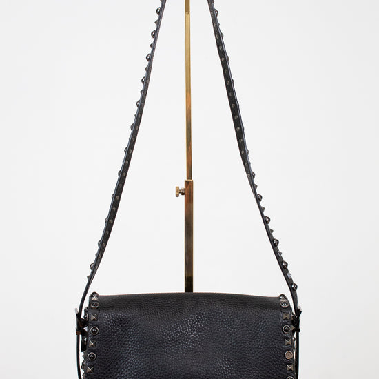 Black leather handbag with chain strap on a white background