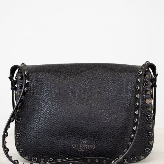 Black leather handbag with studs on a white background