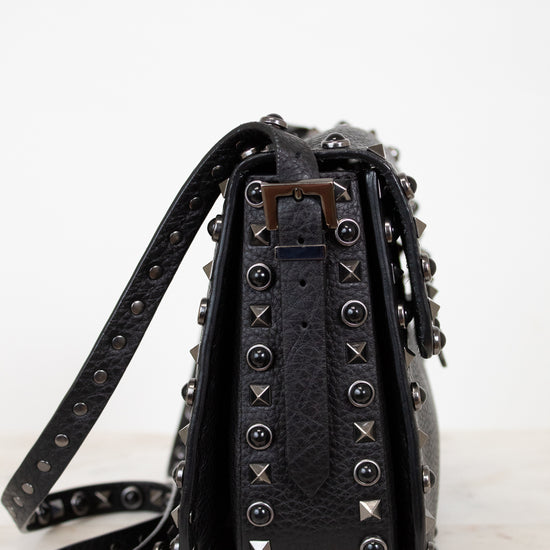 Black studded handbag on a white background