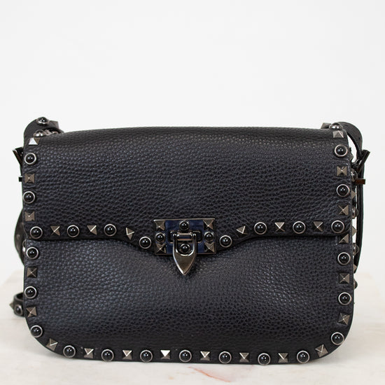 Black leather purse with gunmetal hardware on white background
