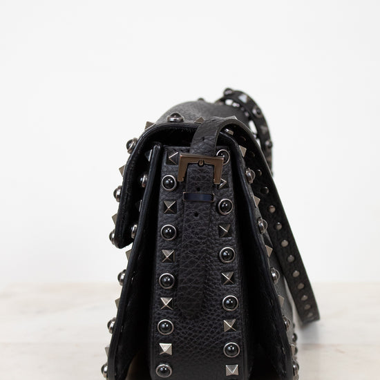 Black studded handbag on a white background