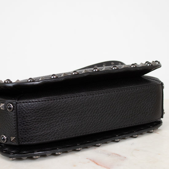 Black studded handbag on a white surface