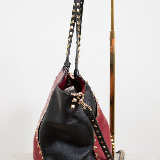 Black and red handbag with studded details on a white background