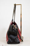 Black and red handbag with studded details on a white background