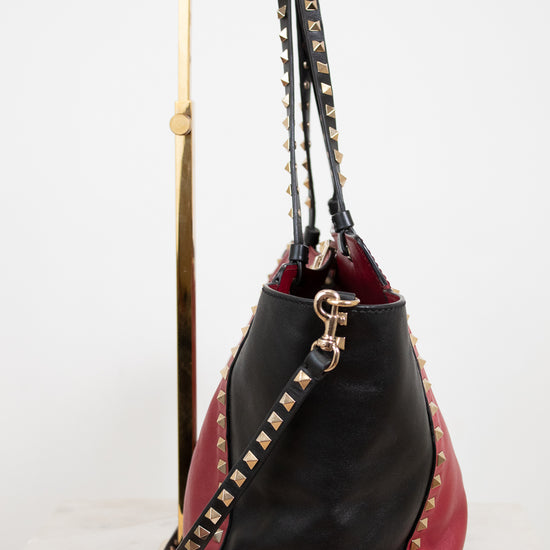 Black and red handbag with gold studs on a white background